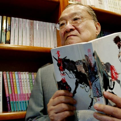 Novelist Louis Cha, who wrote under the name Jin Yong, holds his book "Book and Sword, Gratitude and Revenge" at his office in Hong Kong in 2002. Photo: Reuters