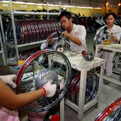 Workers assemble motorcycle parts at a joint venture of Chinese motorcycle company Lifan in Hung Yen Province, Vietnam. Research contends that China has in recent years lost some of its competitive advantage to emerging neighbours such as Vietnam and Malaysia. Photo: Xinhua