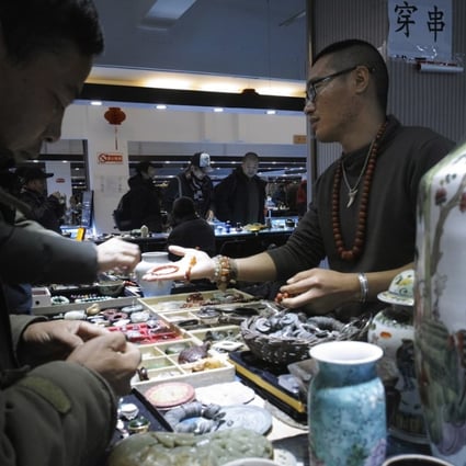 A vendor talks with customers at the Panjiayuan antique market in Beijing. Photo: EPA