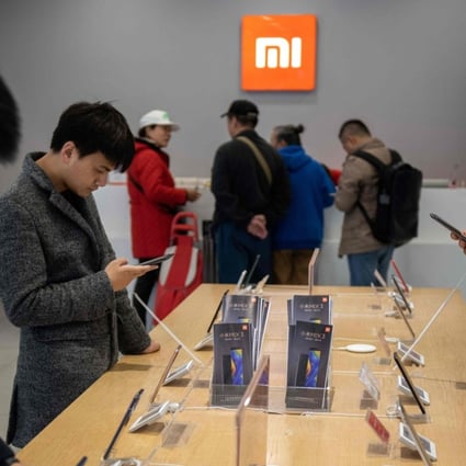 Customers look at mobile phones in a Xiaomi shop in Beijing on November 7, 2018. Photo: AFP