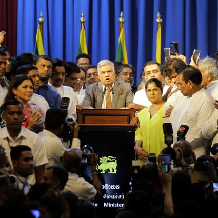 Sri Lanka's reinstated Prime Minister Ranil Wickremesinghe, centre, surrounded by loyal lawmakers and supporters. Photo: AP