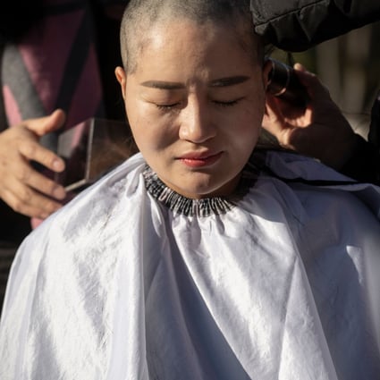 Li Wenzu has her head shaved to protest the detention of her husband, human rights lawyer Wang Quanzhang, in Beijing on Monday. Photo: AFP