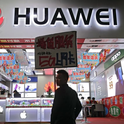 A worker holds a sign promoting a sale for Huawei’s 5G internet services at a mobile phone retail shop in Shenzhen in south China's Guangdong province, Tuesday, Dec 18, 2018. Photo: AP