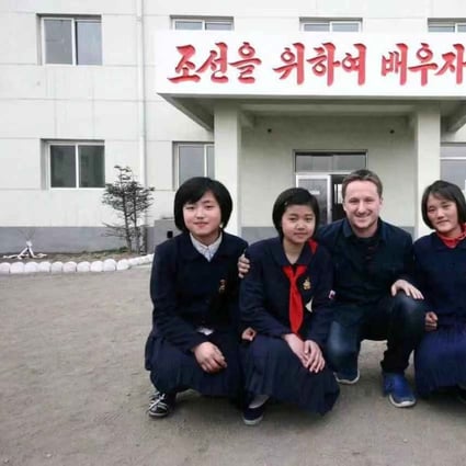 Canadian businessman Michael Spavor poses with girls at a school in North Korea. The characters read: “Let’s study for Korea!” Photo: Reuters