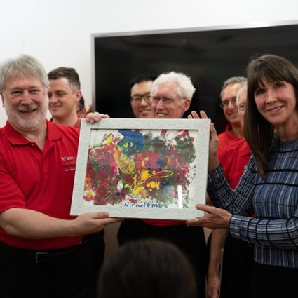 Co-founder Phyllis Marwah presents a painting by one of the children at the Child Care Home to the Hong Kong Male Welsh Choir during their visit. Photo: courtesy of Mother’s Choice