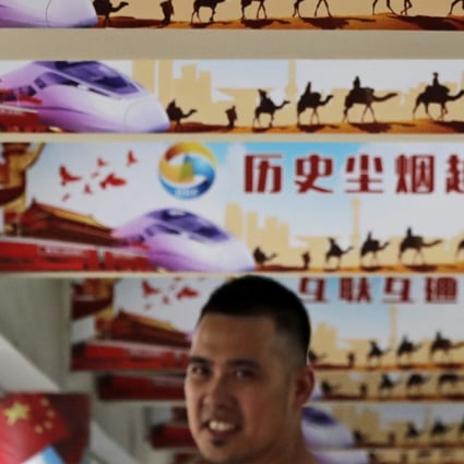 A man stands under signs promoting the “Chinese dream” and “Belt and Road Initiative” during an event in Beijing. The plan has come under increasing scrutiny. Photo: AP