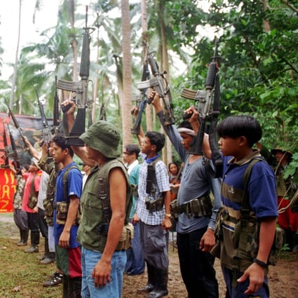 New People's Army guerillas raise their firearms to mark a previous anniversary in 1998. Photo: AP