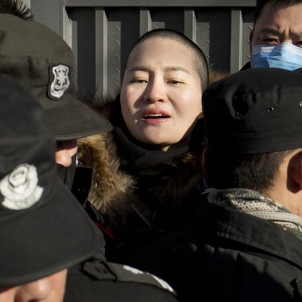 Security officers surround Li Wenzu as she attempts to enter the Supreme People’s Court petition office in Beijing on Friday. Photo: AP