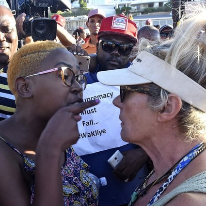 An anti-racism protester (left) argues with an animal-rights activist (right) before the slaughter of a sheep in a supposed anti-racism ritual on Cape Town’s Clifton Beach on Friday. Photo: EPA