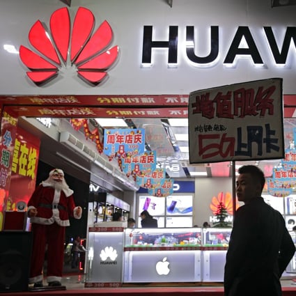 A worker at a retail shop in Shenzhen promotes Huawei 5G products. Photo: AP