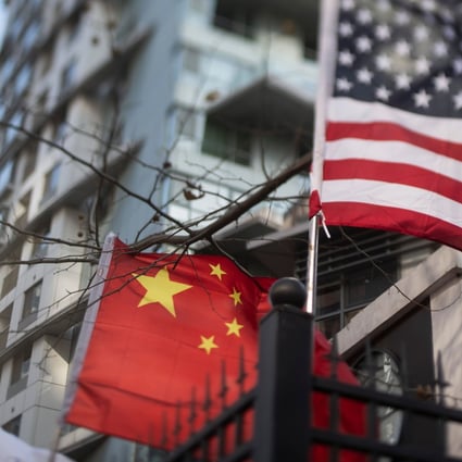 (FILES) In this file photo taken on December 05, 2018, a Chinese and US national flags hang on a fence at an international school in Beijing, China. – The US central bank sent a strong signal on Friday, December 21, 2018 that it would be willing to reconsider expected interest rate increases amid new data showing President Donald Trump's multi-front trade wars are dragging on the economy and shaking up investors. (Photo by FRED DUFOUR / AFP)