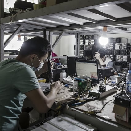 Technicians make repairs to bitcoin mining machines at a mining facility operated by Bitmain in Ordos, Inner Mongolia. Photo: Bloomberg