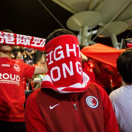 A Hong Kong fan covers his face during the Chinese national anthem before an international friendly soccer match between Hong Kong and Bahrain at Mong Kok Stadium. Photo: AFP