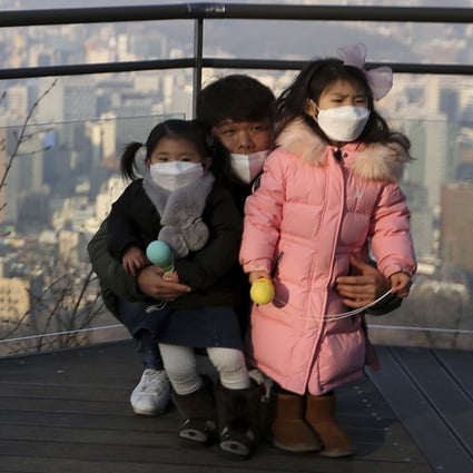 A family wears masks to protect themselves from a thick haze of fine dust in Seoul. Photo: AP
