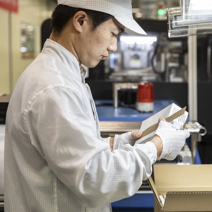 An employee inspects a box on the assembly line of a Huawei Technologies mobile phone plant in Dongguan, China, on Tuesday. Photo: Bloomberg