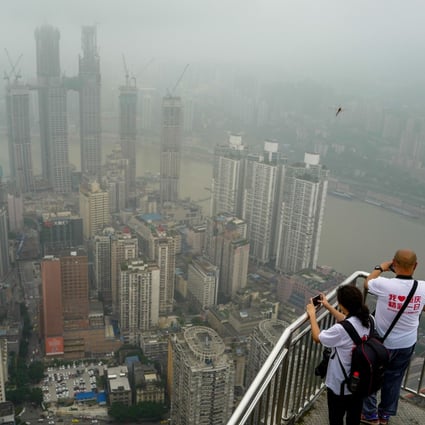People take photos of Chongqing on June 18. A property market downturn is expected in 2019, contributing to doubts about the overall health of the world’s second-largest economy. Photo: Xinhua