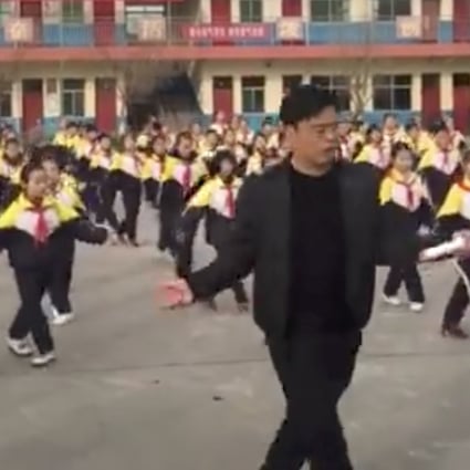 School principal Zhang Pengfei leads the dance routine in front of Xi Guan Primary School. Photo: Handout