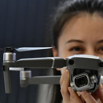 A hostess presents the Mavic 2 Pro drone at the booth of DJI during a trade show in Berlin on August 30, 2018. Photo: AFP