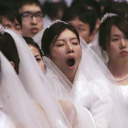 A bride yawns during a mass wedding held in Gapyeong, South Korea, in August. Photo: AP