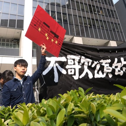 Joshua Wong and other members of his Demosisto party display a banner reading “Freedom not to sing praises” outside the Hong Kong government headquarters. Photo: Dickson Lee