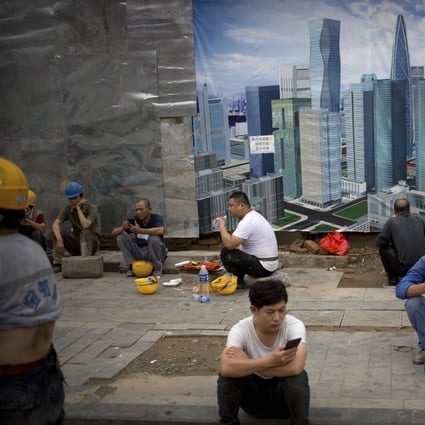 Construction workers take their lunch break outside a construction site in Beijing. Photo: AP