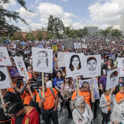 Marchers carry the portraits of 17 who lost their lives in the Parkland High School shooting, drawn by Gracie Pekrul, 16, student of Simi Valley Oak Park Independent School, at the March For Our Lives rally in Los Angeles on Saturday, March 24, 2018. (Irfan Khan/Los Angeles Times/TNS)