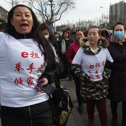 Investors in Chinese online peer-to-peer lender Ezubao chant slogans during a protest in Beijing in February 2016. Photo: AFP
