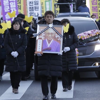 A mourner with a portrait of the deceased Kim Bok-dong. Photo: AP