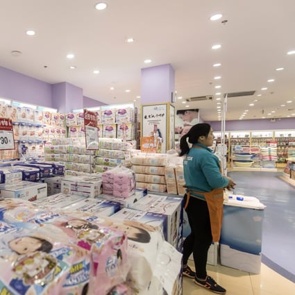 An employee next to diapers displayed for sale at a Shanghai Aiyingshi Co. Babemax store in Shanghai, China, in 2017. Photo: Bloomberg