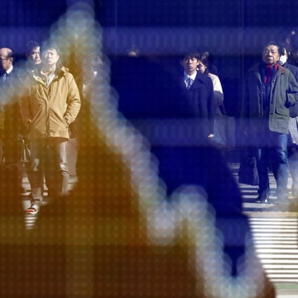 Pedestrians are reflected in a stock market indicator board in Tokyo, Japan, on January 29. Economics can no longer be allowed to run riot, independent of politics, sociology and ecology. It just does not add up. Photo: EPA-EFE