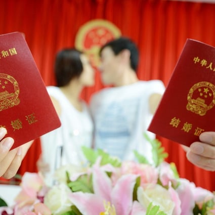 A young couple show off their marriage certificates as they seal the deal with a kiss. Authorities in Puyang, Henan province, have issued guidelines aiming to “curb the high cost of betrothal gifts and change the custom”. Photo: China Foto Press