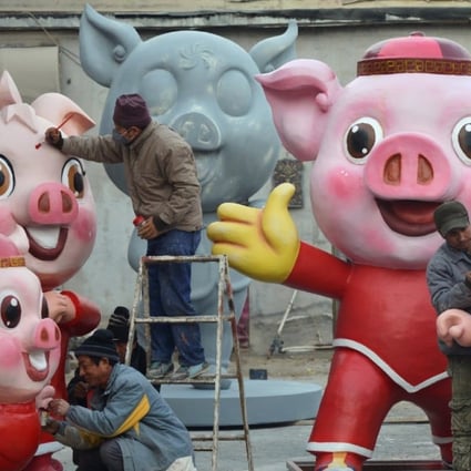 Men work on pig sculptures in preparation for the upcoming Lunar New Year of the Pig, in the Changping district of Beijing. Photo: Reuters