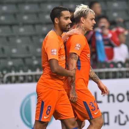 Roger Guedes is congratulated by teammates after scoring for Shandong Luneng. Photo: HKFA