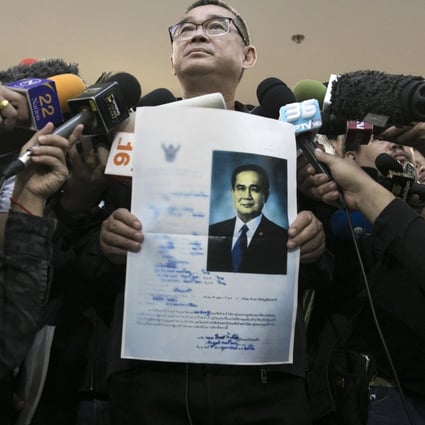 Reungkrai Leekijwatana, an official with the Thai Raksa Chart party, holds a copy of Prime Minister Prayuth Chan-Ocha's candidacy application as he speaks to members of the media at the office of the Election Commission in Bangkok, Thailand. Photo: Bloomberg