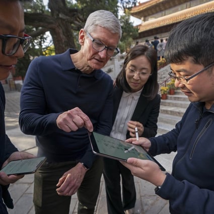 Apple chief executive Tim Cook watches how a person writes calligraphy on an iPad with an Apple Pencil at the Beijing Confucian Temple in the Chinese capital on October 10, 2018. Photo: Xinhua