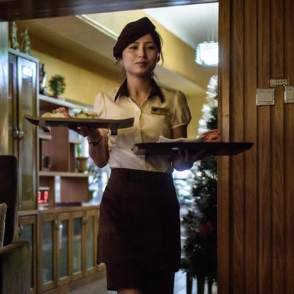 A staff member serves food at the SoGwang Green Leaf Coffee Shop in Pyongyang. Photo: AFP