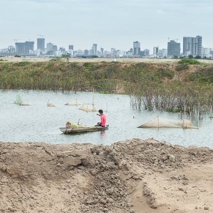 A young man trying to fish in Boeung Tompun next to a recent sand filled site in Phnom Penh. Photo: Enric Catala