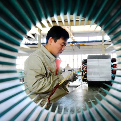 A man works on an electric machine parts at a workshop of an equipment manufacturing company in Weifang, Shandong province, China. Photo: Reuters