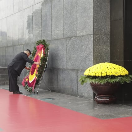 Kim adjusts a wreath during a ceremony at Ho Chi Minh Mausoleum in Hanoi on March 2, 2019. Photo: Bloomberg