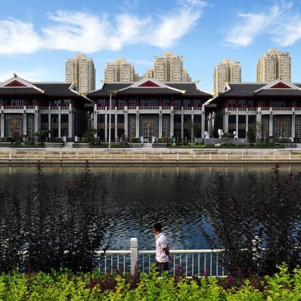 Expensive lakeside villas stand in front of public housing in the Chaoyang district of Beijing. Luxury property sales have been declining in China. Photo: AFP