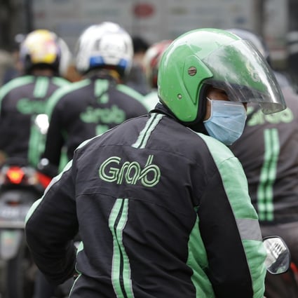A GrabBike driver rides on his motorcycle in Jakarta, Indonesia. Southeast Asian ride-hailing app operator Grab is expanding into financial services in partnership with a Japanese credit card company, hoping to offer credit to millions of people without bank accounts. Photo: AP