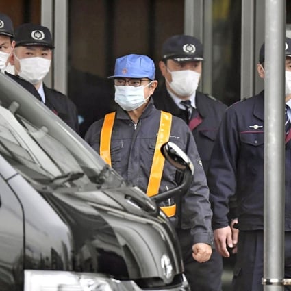Ghosn (wearing blue cap) leaves the Tokyo Detention House on March 6, 2019. Photo: Reuters.
