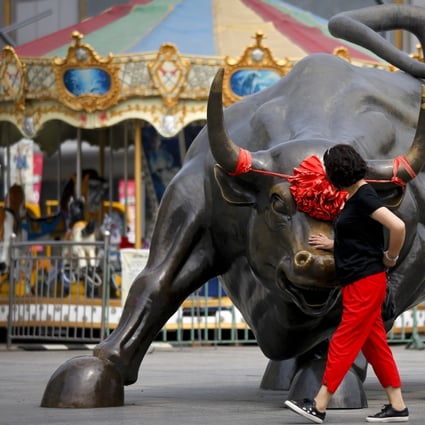 China’s markets are on fire. Here, a Chinese woman touches a bull statue on display in Beijing on June 18, 2018. Photo: Associated Press