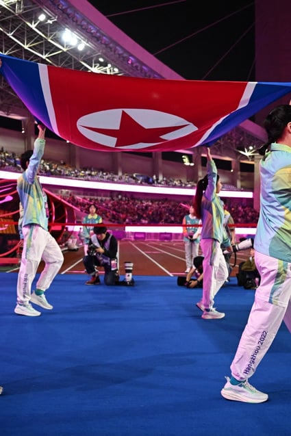 Volunteers carrying the North Korea flag walk out at Huanglong Sports Centre Stadium ahead of the women’s football gold medal match between Japan and North Korea at the Asian Games in Hangzhou. Photo: Reuters