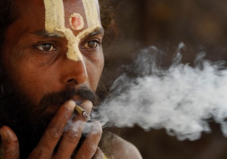 A Hindu holy man smokes ‘bidi’, or a small hand-rolled Indian cigarette, in Allahabad. File photo: AP