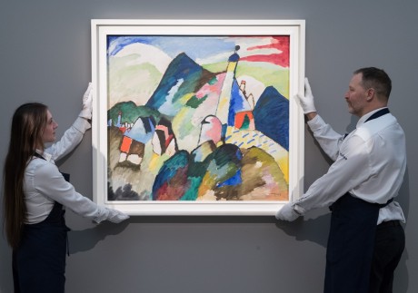 Art handlers hold a 1910 painting by Wassily Kandinsky, “Murnau mit Kirche II” (Murnau with Church II), which recently sold for US$45 million. Kandinsky is one of the artists featured in Netflix series “The Greatest Painters in the World”. Photo:  Wiktor Szymanowicz/Anadolu Agency via Getty Images