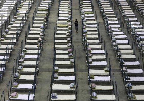 A worker walks among beds in a convention centre that has been converted into a temporary hospital in Wuhan, Hubei, on February 4. Photo: AP