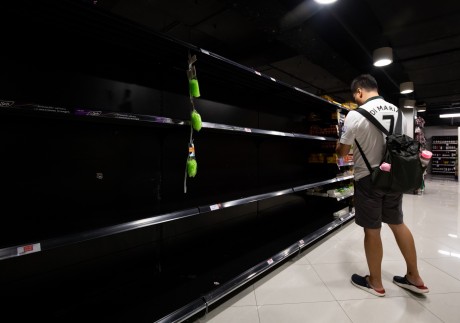 A customer stands in front of empty shelves in the toilet paper aisle of a supermarket in Singapore on February 8. Photo: Bloomberg