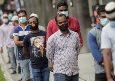 Migrant workers wear masks while queuing at a meal distribution point in the Little India district of Singapore on May 6. Photo: EPA-EFE