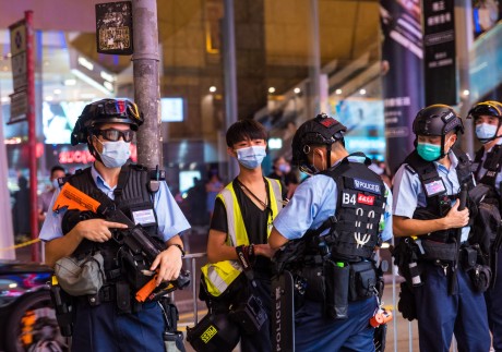 A student journalist is subject to a stop and search by riot police on Portland street in Mongkok in Hong Kong, China. Photo: Getty Images